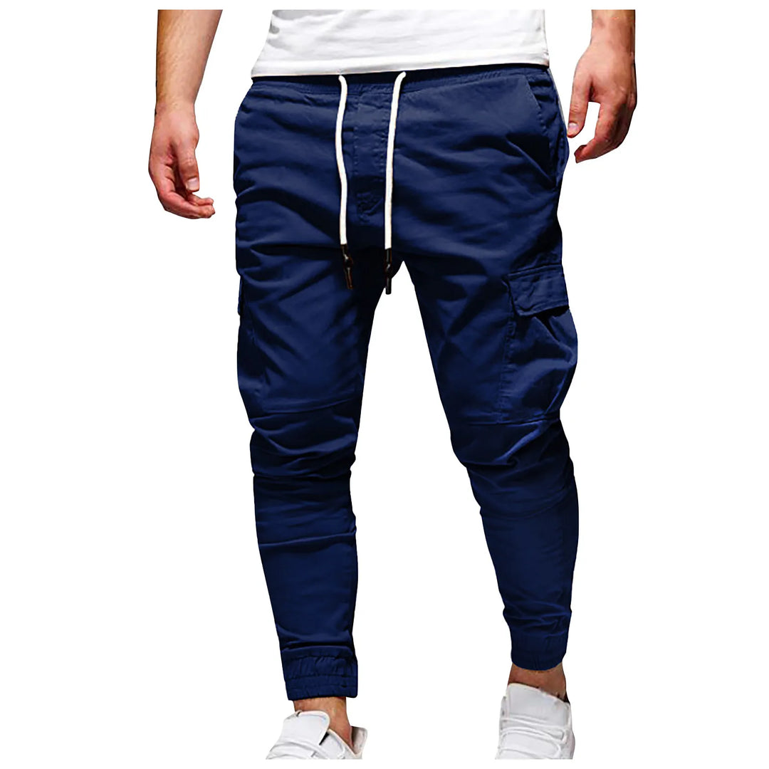 Navy blue jogger pants worn by a person on a white background