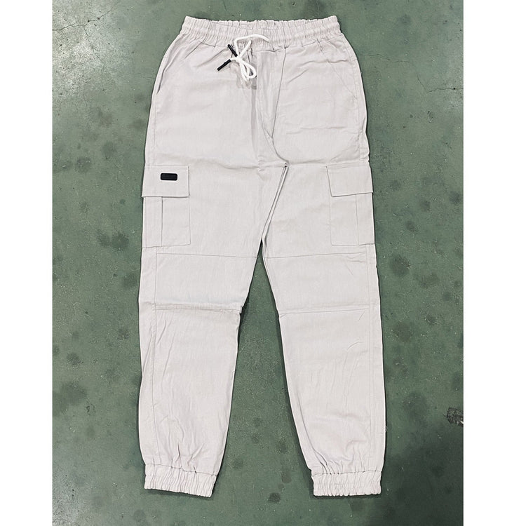 Light-colored pants laid flat on a textured green surface