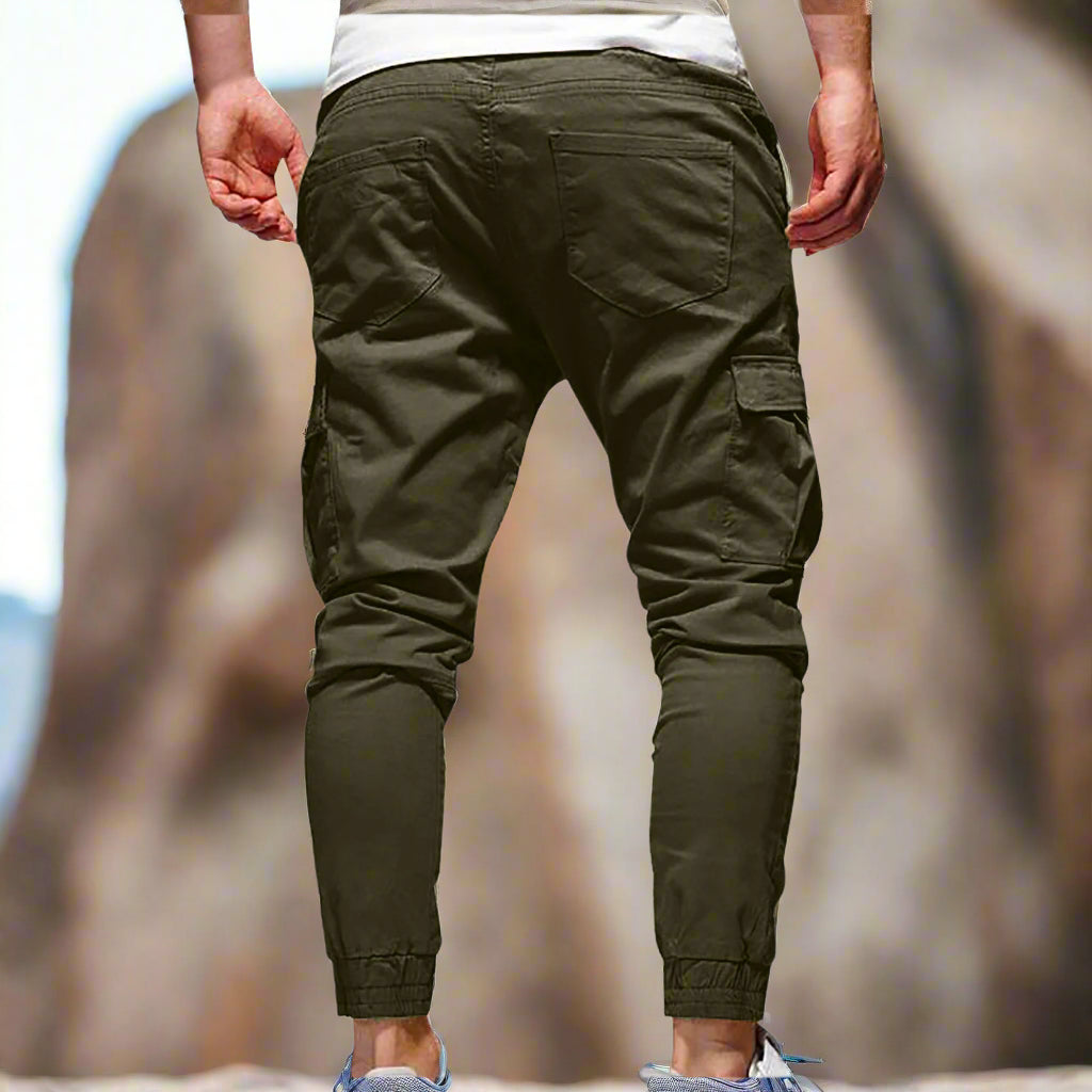Green cargo pants worn by a person on a white background