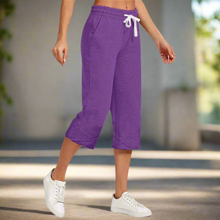 Purple capri sweatpants worn by a person on a white background