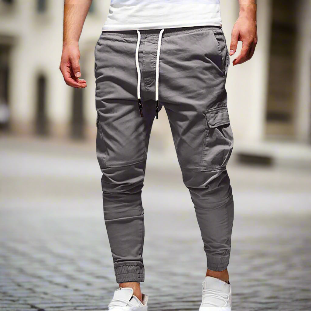 Gray jogger pants with a white drawstring on a white background