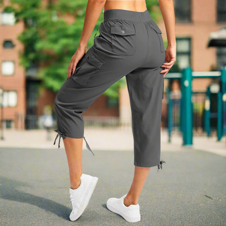 Person wearing gray capri pants on a white background