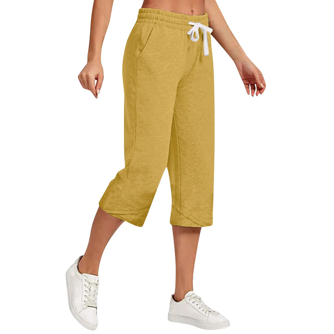 Yellow capri pants worn by a person on a white background